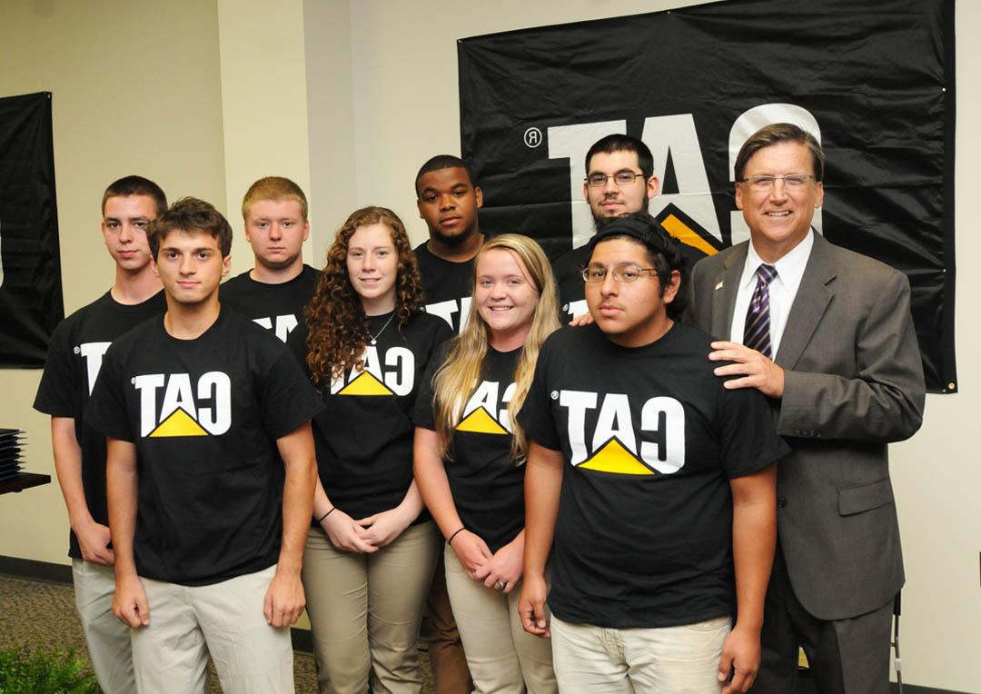 Click to enlarge,  Gov. Pat McCrory (left) and other government, education and industry leaders gathered at Caterpillar Inc.'s Sanford Fabrication Facility in the Lee County Industrial Park May 15 to celebrate the achievements of the first group of students to graduate from the Caterpillar Youth Apprentice Program in welding. The graduates are (front, from left) George Alfaro and Ashley Stack, of Southern Lee High School; Briana Peterman, of Lee County High School; and Biagio Esposito, of Southern Lee; and (back, from left) James Kirik, of Lee County High; and Antonio Murchison, Anthony Woodlief, and Steven Bouldin, all of Southern Lee. The two-year program is a collaboration of Caterpillar, Central Carolina Community College, Lee County Schools, and the N.C. Department of Commerce. For more information about the welding apprentice program, contact Lee County Schools Career Development coordinators Gary Hart, at Southern Lee, ghart.sl.lee.k12.nc.us, or Alison Poole at Lee County High, apoole.ls@lee.k12.nc.us. At <a href='http://z8il.thebetterlife.net'>推荐正规买球平台</a>, contact Dr. Stephen Athans, dean of Vocational/Technical Programs, 919-718-7287, sathans@thebetterlife.net. 